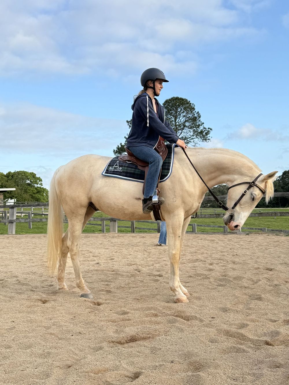 Girl riding a palomino in the arena